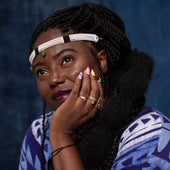 Woman wearing a blue patterned garment against a dark background