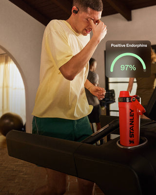 Person on a treadmill with a Stanley shaker and a digital display showing positive endorphins.