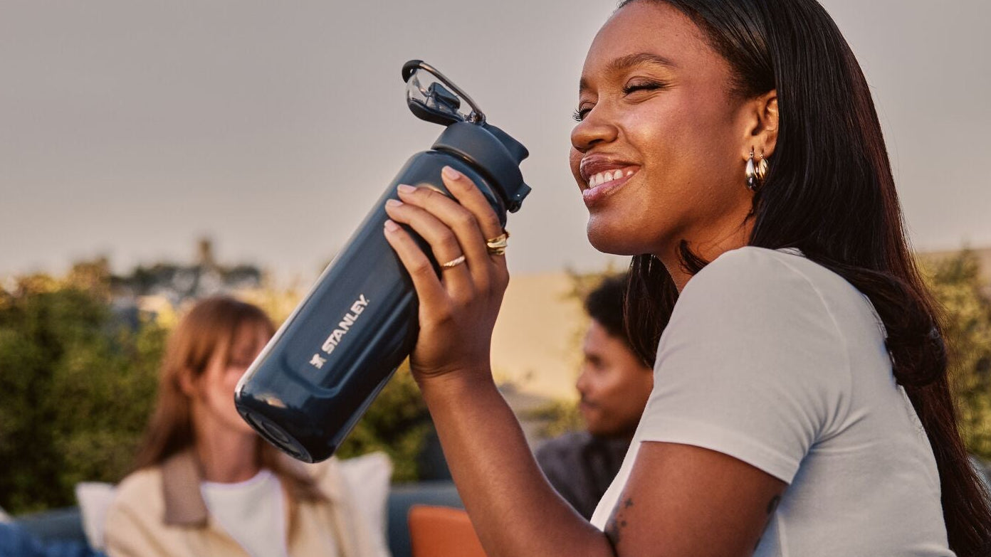 Woman holding a black water bottle with a scenic background