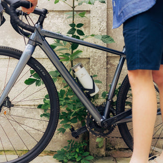 Front shot camera of a model's bike focusing on the travel mug